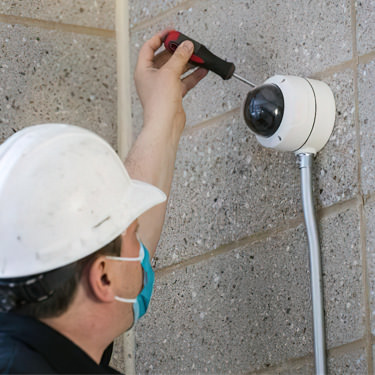 Sonitrol worker installing exterior security camera